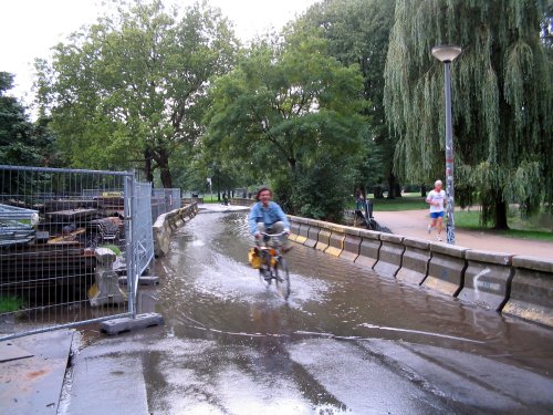 Man fietst door plas water